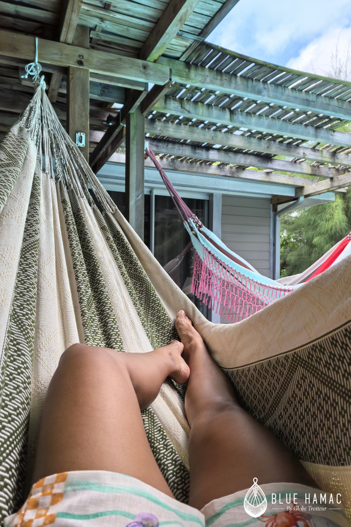 hamac elegant magnifique beige et vert olive grandes franges tissées et brodées relaxée sur une terrasse couverte en guadeloupe entièrement fait main modèle unique vue du hamac