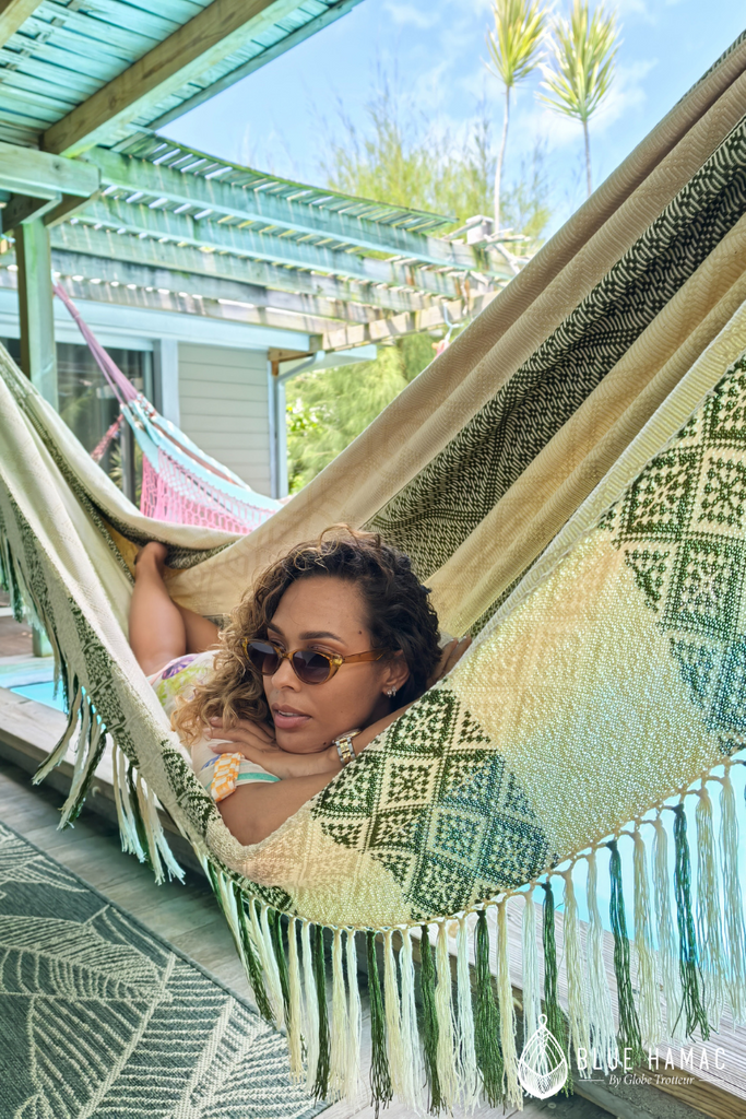 hamac elegant magnifique beige et vert olive grandes franges tissées et brodées relaxée sur une terrasse couverte en guadeloupe entièrement fait main modèle unique mathilda crampon détendue 
