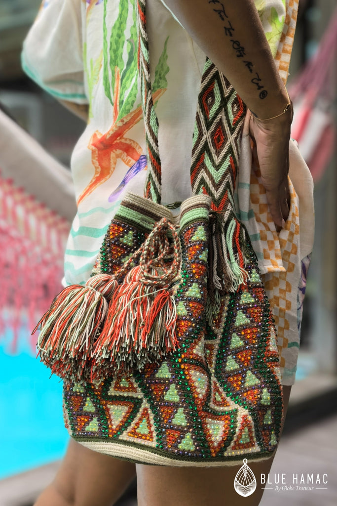 Sac colombien tissé à la main, orné de motifs aztecks vert orange et marron porté par mathilda crampon. Fabriqué par des artisans locaux, ce sac allie tradition et modernité. Parfait pour un usage quotidien, il offre à la fois style et fonctionnalité, tout en mettant en valeur un savoir-faire authentique.