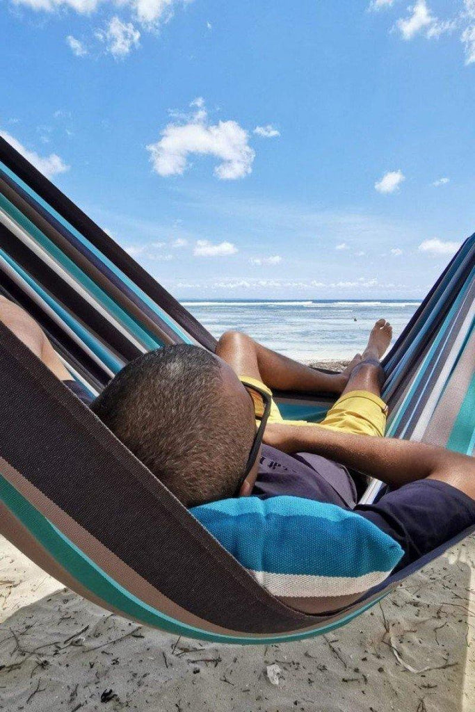 hamac large en coton bleu turquoise gris et noir, sur une plage paradisiaque en guadeloupe confort et élégance, vue du hamac