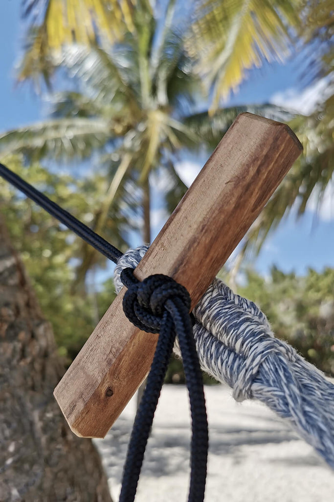 hamac gris en coton large avec pompons et franges élégance et confort pour plage, jardin ou terrasse couverte détails de la fixation à la plage 